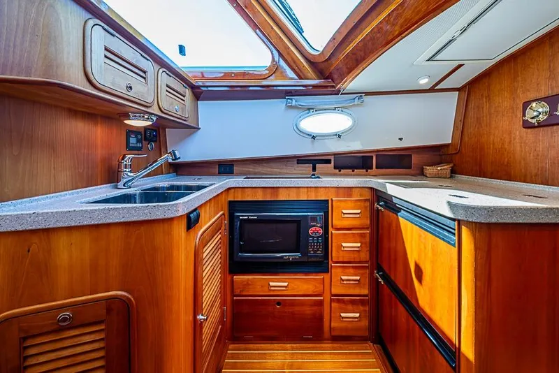 Slide: The Image of Luxurious 2008 Hinckley Talaria 44 MY yacht kitchen with wood cabinetry and modern appliances. - 20
