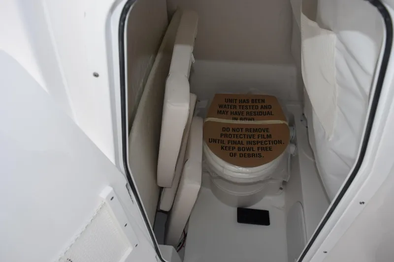 Slide: The Image of Interior of 2026 Sea Hunt Ultra 245 SE boat with toilet and protective cover. - 15