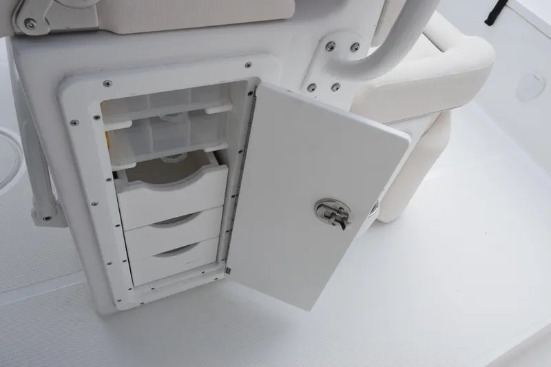 Slide: The Image of Open storage compartment on 2026 Sea Hunt Ultra 245 SE boat, featuring organized drawers. - 16