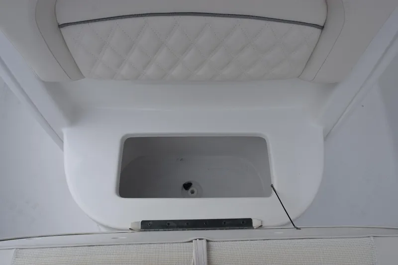 Slide: The Image of 2026 Sea Hunt Ultra 245 SE boat interior with storage compartment and cushioned seating. - 19