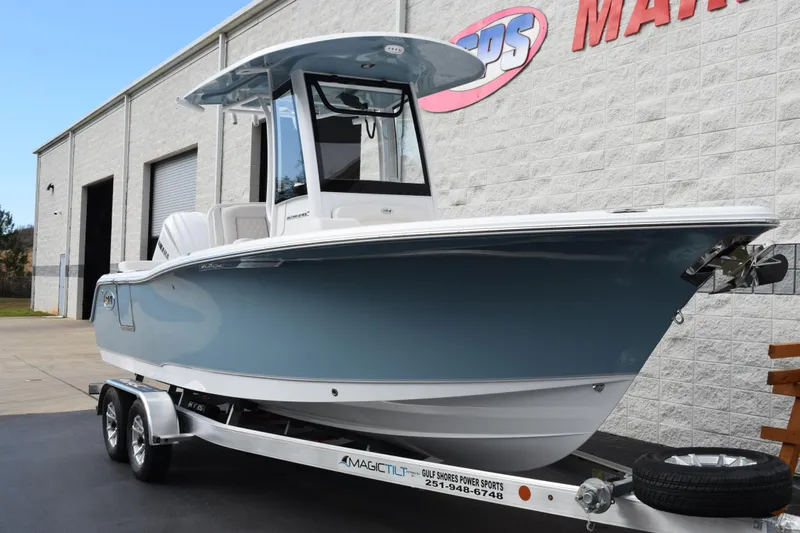 Slide: The Image of 2026 Sea Hunt Ultra 245 SE boat on trailer outside a marine dealership. - 2