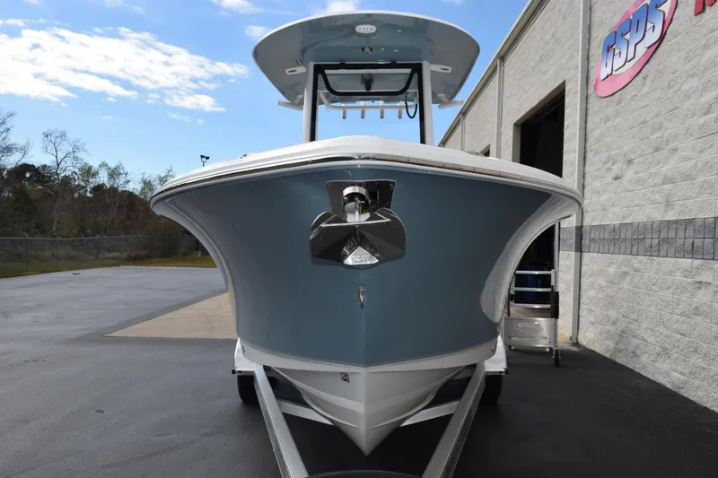 Slide: The Image of 2026 Sea Hunt Ultra 245 SE boat, front view, parked outdoors near a building. - 3