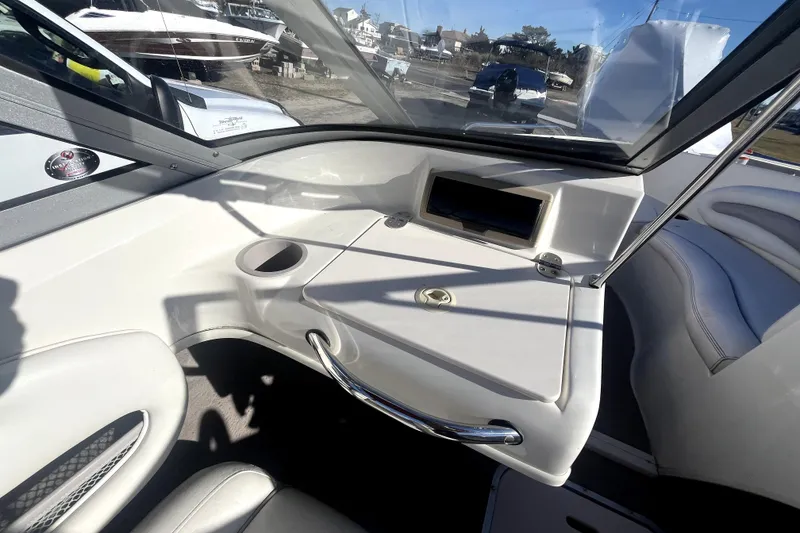 Slide: The Image of 2007 Stingray 185 LS/LX boat interior with white and red seating, cup holders, and sleek design. - 13