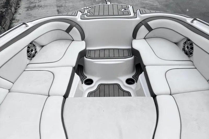 Slide: The Image of 2014 Yamaha Boats 242 Limited S interior with white cushioned seating and cup holders. - 4