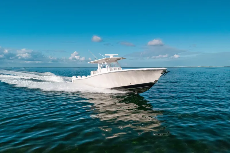The Image of 2016 Invincible 42 Open Fisherman boat cruising on clear blue ocean waters. - 0
