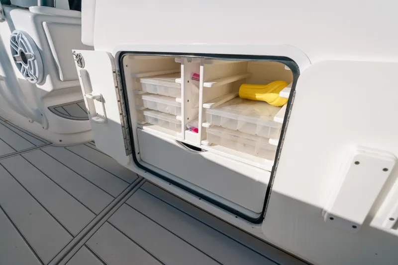 Slide: The Image of Open storage compartment on 2016 Invincible 42 Open Fisherman boat with organized tackle boxes. - 16
