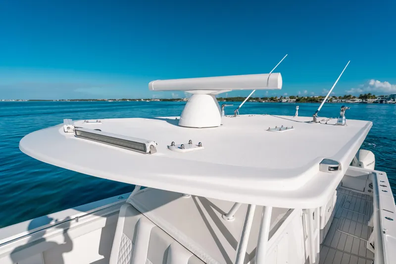 Slide: The Image of 2016 Invincible 42 Open Fisherman boat on calm blue waters, featuring radar equipment. - 20