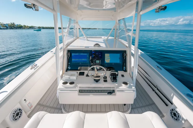 Slide: The Image of 2016 Invincible 42 Open Fisherman boat cockpit with advanced navigation systems on calm water. - 26