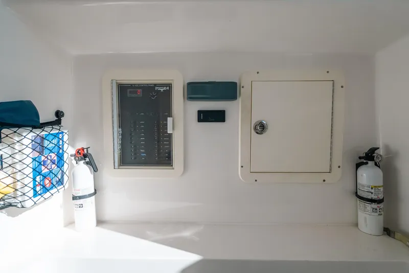 Slide: The Image of 2016 Invincible 42 Open Fisherman control panel with fire extinguishers and storage compartment. - 32