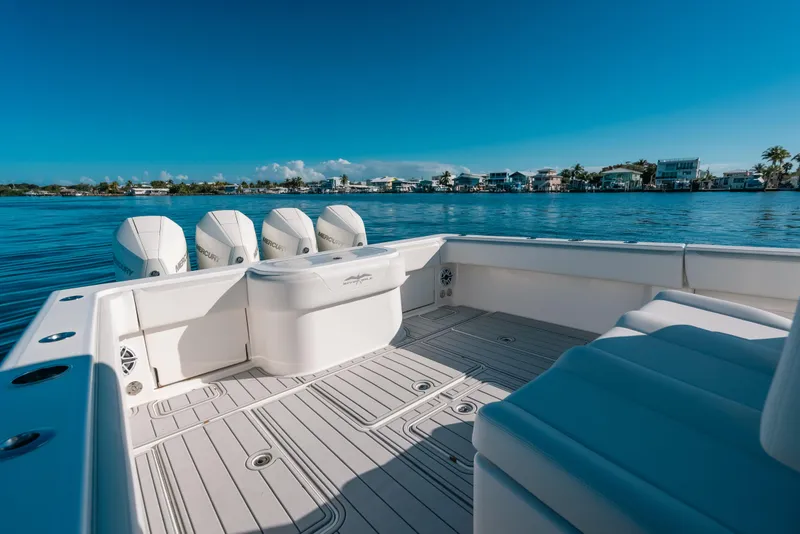 Slide: The Image of 2016 Invincible 42 Open Fisherman boat on calm water, featuring multiple outboard engines. - 36