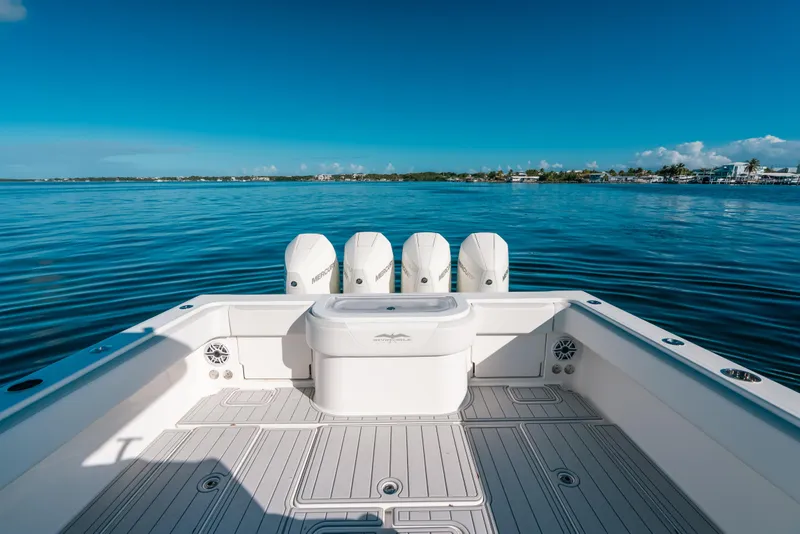 Slide: The Image of 2016 Invincible 42 Open Fisherman boat on calm blue waters, featuring multiple outboard engines. - 38