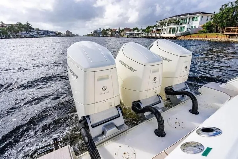 Slide: The Image of 2022 Boston Whaler 420 Outrage with triple Mercury outboard engines on a scenic waterway. - 18