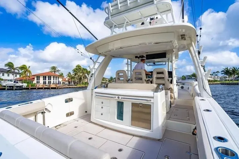Slide: The Image of 2022 Boston Whaler 420 Outrage boat on water, featuring spacious deck and seating. - 19
