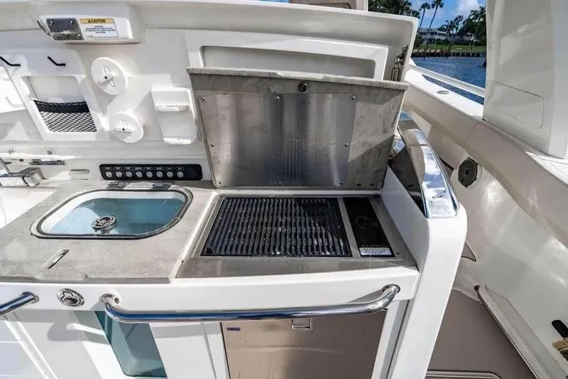Slide: The Image of Boston Whaler 420 Outrage 2022 boat kitchen with sink and grill. - 22