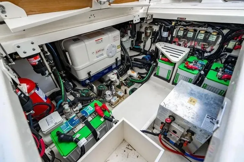 Slide: The Image of Engine room of 2022 Boston Whaler 420 Outrage, showcasing batteries and equipment. - 24
