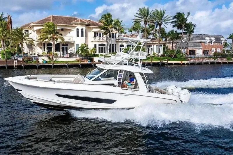Slide: The Image of 2022 Boston Whaler 420 Outrage cruising near luxury waterfront homes. - 3