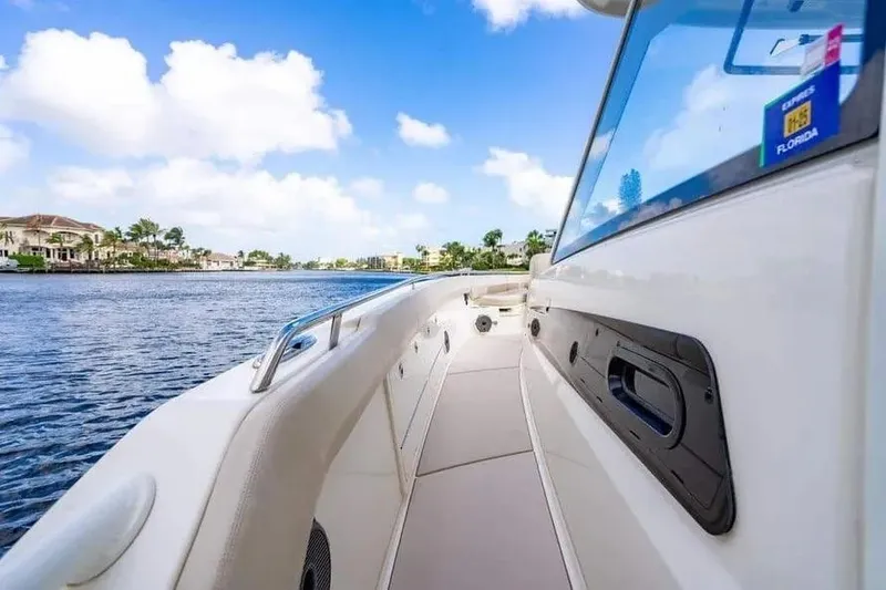 Slide: The Image of 2022 Boston Whaler 420 Outrage boat on a sunny day, cruising near waterfront homes. - 33