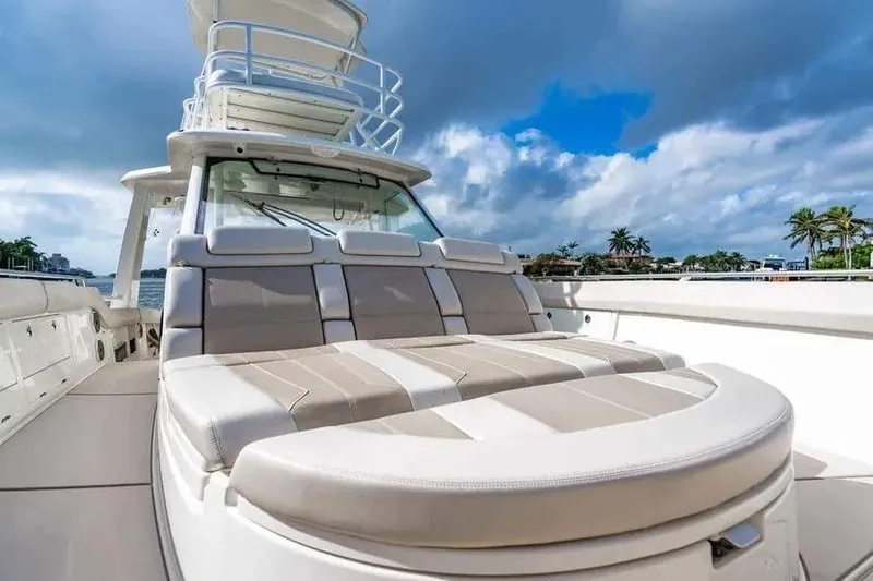 Slide: The Image of 2022 Boston Whaler 420 Outrage boat with luxurious seating, under a partly cloudy sky. - 36