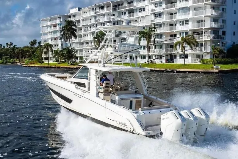 Slide: The Image of 2022 Boston Whaler 420 Outrage cruising near waterfront buildings. - 6