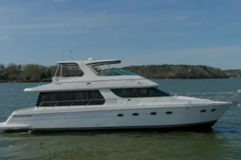 The Image of 2005 Carver 570 Voyager Pilothouse yacht on calm water, side view. - 1