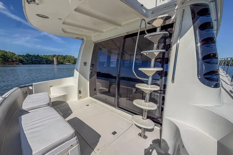 Slide: The Image of 2005 Carver 570 Voyager Pilothouse yacht deck with spiral staircase and waterfront view. - 13
