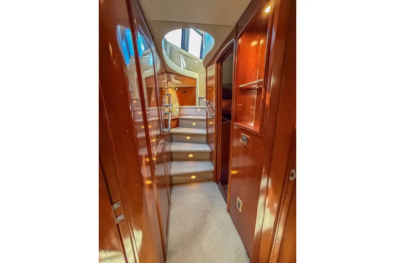 Slide: The Image of Luxurious interior of 2005 Carver 570 Voyager Pilothouse yacht with wooden finishes and carpeted stairs. - 29