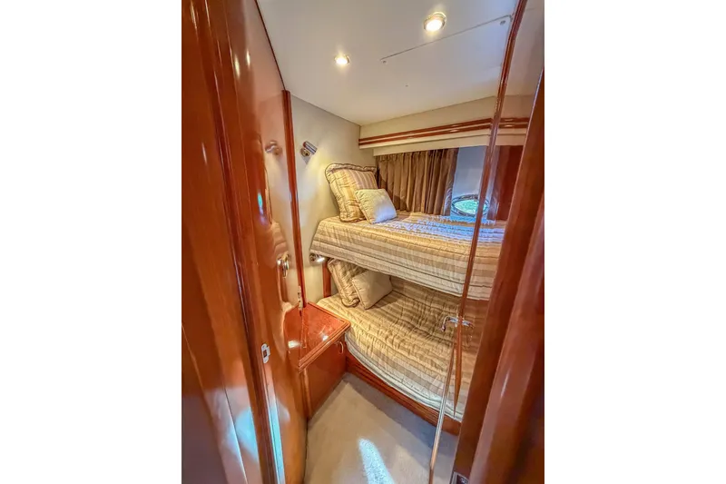 Slide: The Image of Bunk beds in 2005 Carver 570 Voyager Pilothouse yacht cabin, featuring wood paneling and cozy lighting. - 42