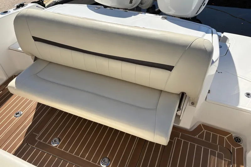 Slide: The Image of 2012 Nor-Tech 340 Sport Center Console boat seat with beige upholstery and teak flooring. - 19