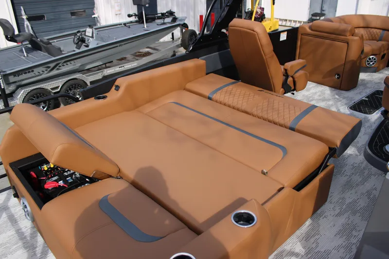 Slide: The Image of Luxurious brown seating on 2026 Starcraft RX 23 Q DH boat, featuring cup holders and storage. - 17