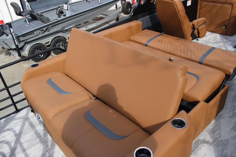 Slide: The Image of 2026 Starcraft RX 23 Q DH boat interior with tan leather seating and cup holders. - 18