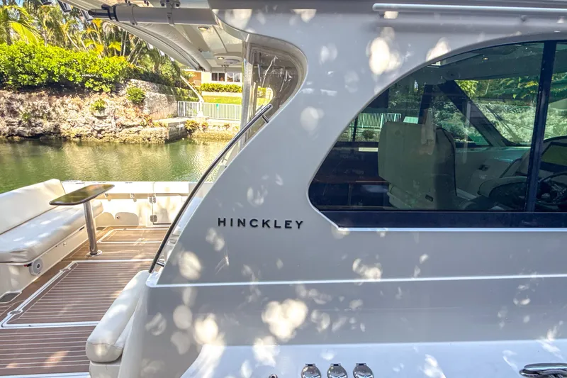 Slide: The Image of 2021 Hinckley Sport Boats 40x with extended sunshade under clear blue sky. - 15