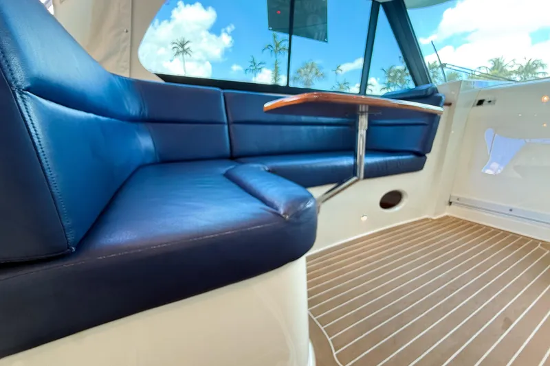 Slide: The Image of Luxurious seating area on 2021 Hinckley Sport Boats 40x with blue cushions and wooden table. - 23