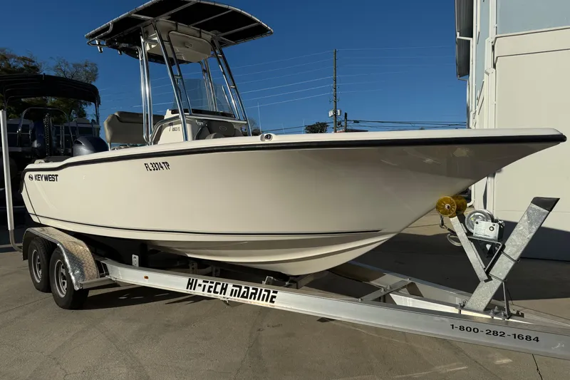 The Image of 2023 Key West 203 FS boat on trailer, displayed outdoors under clear blue sky. - 1
