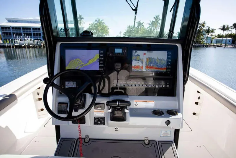 Slide: The Image of 2026 World Cat 325 CC boat interior with seating and storage, on a calm river. - 11