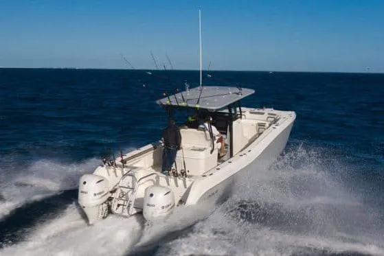 Slide: The Image of 2026 World Cat 325 CC boat navigating through calm waters near lush greenery. - 3