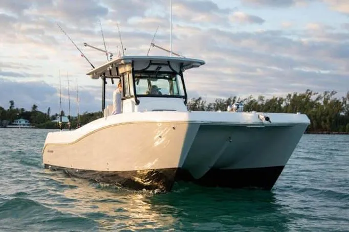 Slide: The Image of 2026 World Cat 325 CC boat on calm water, featuring dual outboard engines. - 6