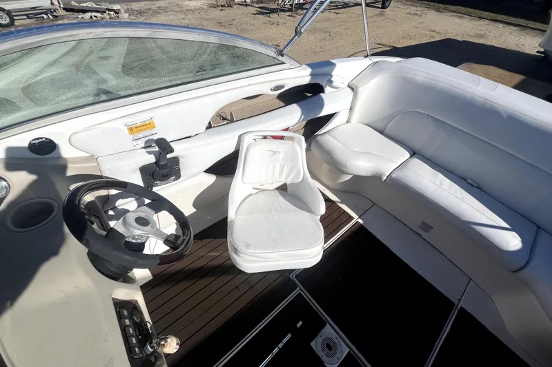 Slide: The Image of 2002 Chaparral 216 SSi boat interior with white seating and steering wheel. - 8