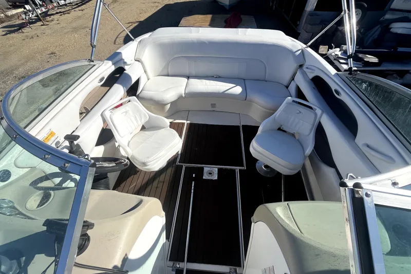 Slide: The Image of 2002 Chaparral 216 SSi boat interior with white seating and wooden flooring. - 9