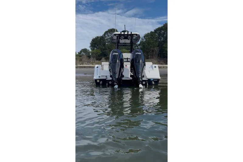 Slide: The Image of 2024 Tidewater 256 LXF boat with dual 150 horsepower engines in shallow water. - 3