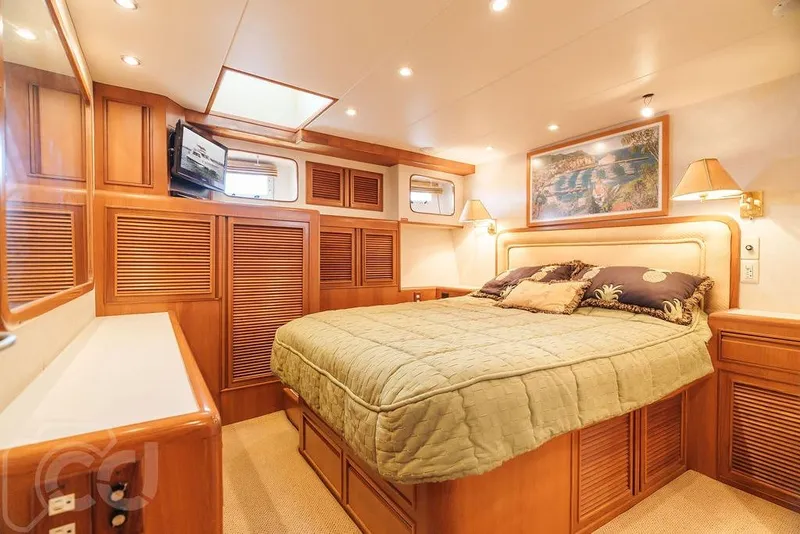 Slide: The Image of Luxurious cabin interior of 1999 Offshore Yachts 52 Pilothouse with cozy bed and elegant wood finish. - 19