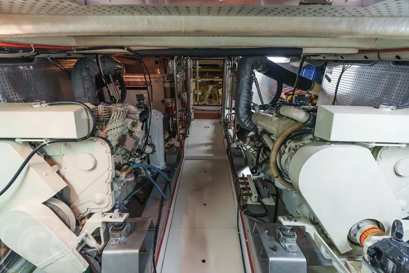 Slide: The Image of Engine room of a 1999 Offshore Yachts 52 Pilothouse, showcasing dual engines and mechanical systems. - 22