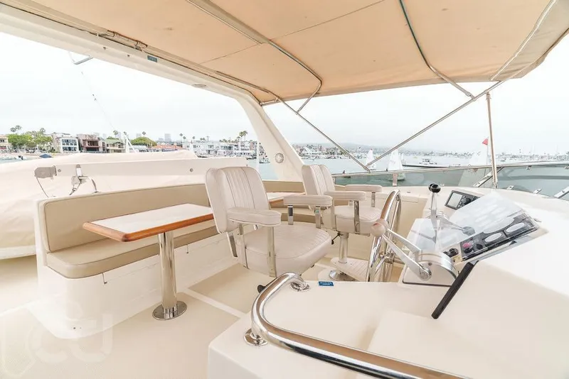 Slide: The Image of 1999 Offshore Yachts 52 Pilothouse interior with helm, seating, and marina view. - 6