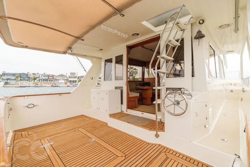 Slide: The Image of 1999 Offshore Yachts 52 Pilothouse, spacious deck with teak flooring and elegant interior. - 8