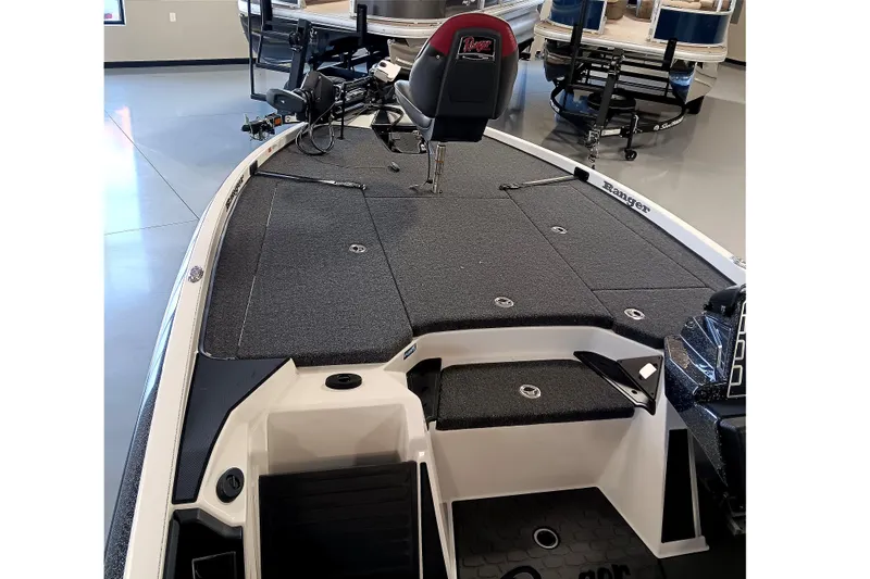 Slide: The Image of 2025 Ranger Z520 boat interior with gray deck and seating, displayed in showroom. - 11