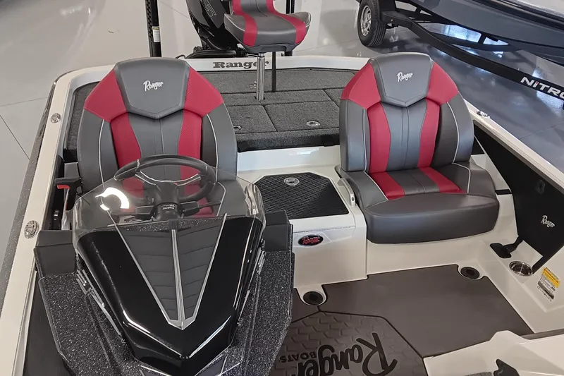 Slide: The Image of 2025 Ranger Z520 boat interior with red and gray seats, steering console, and deck. - 13