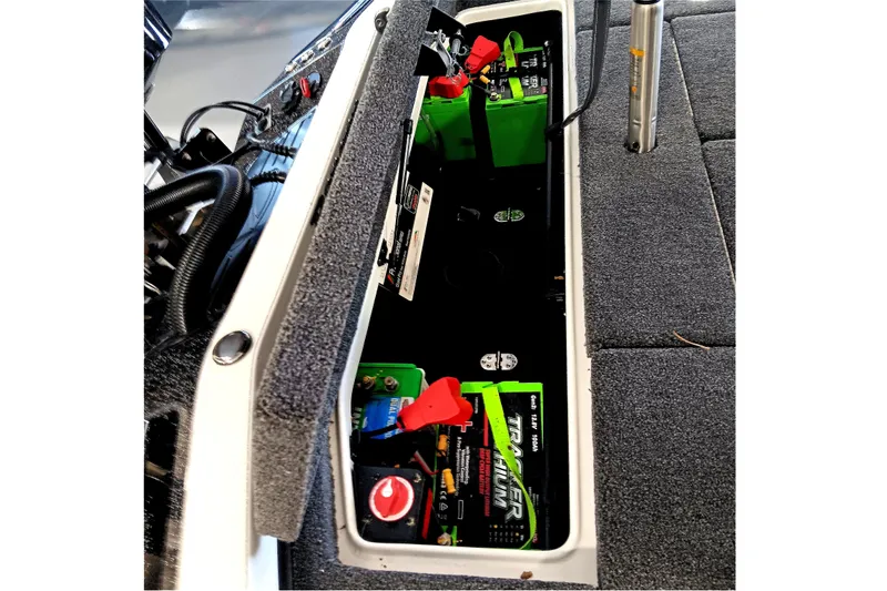 Slide: The Image of 2025 Ranger Z520 boat battery compartment with green batteries and wiring. - 17