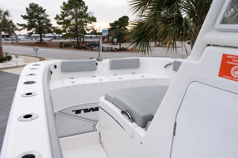 Slide: The Image of 2023 Twin Vee 280 GFX CC boat interior with seating, docked near palm trees. - 19