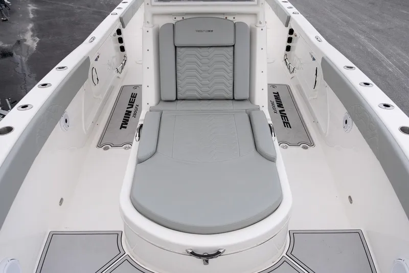 Slide: The Image of 2023 Twin Vee 280 GFX CC boat interior with gray seating and branded flooring. - 20
