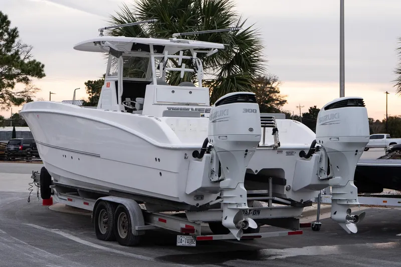 Slide: The Image of 2023 Twin Vee 280 GFX CC boat on trailer with dual Suzuki engines. - 4