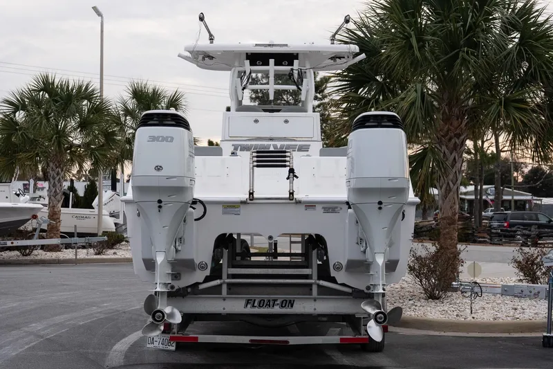 Slide: The Image of 2023 Twin Vee 280 GFX CC boat on trailer, rear view with dual engines. - 5